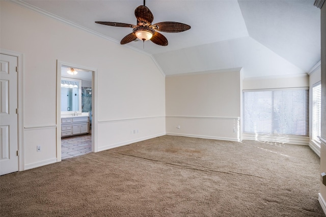 carpeted empty room with ceiling fan, vaulted ceiling, and ornamental molding