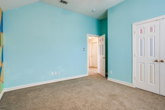 unfurnished bedroom with light carpet, vaulted ceiling, and a closet