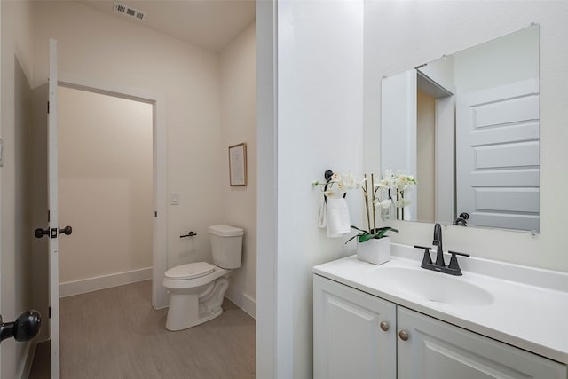 bathroom with wood-type flooring, vanity, and toilet