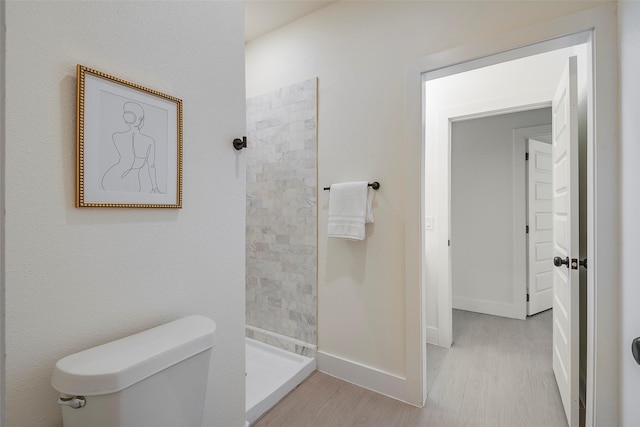 bathroom featuring hardwood / wood-style floors, toilet, and walk in shower