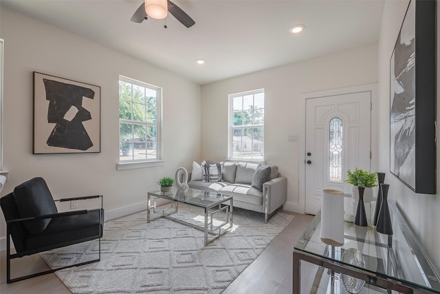 living room with ceiling fan, a wealth of natural light, and light hardwood / wood-style flooring