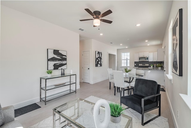 living room featuring light hardwood / wood-style floors and ceiling fan