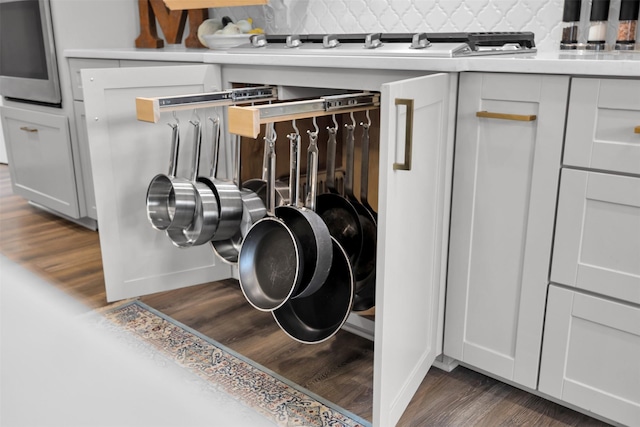 details with decorative backsplash, white cabinetry, and dark hardwood / wood-style floors