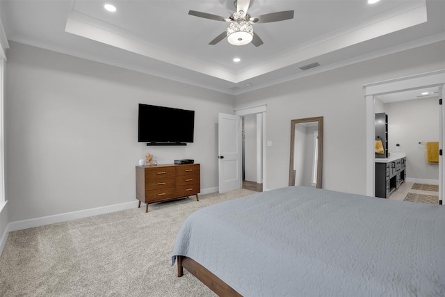 carpeted bedroom featuring a raised ceiling, crown molding, connected bathroom, and ceiling fan