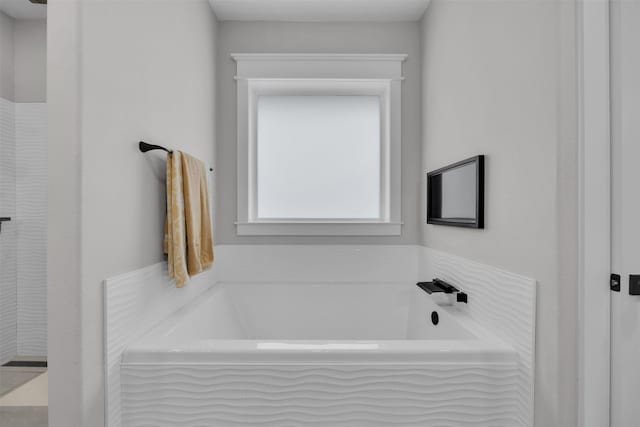 bathroom featuring a relaxing tiled tub