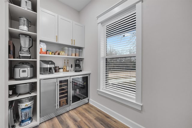 bar with white cabinets and hardwood / wood-style floors