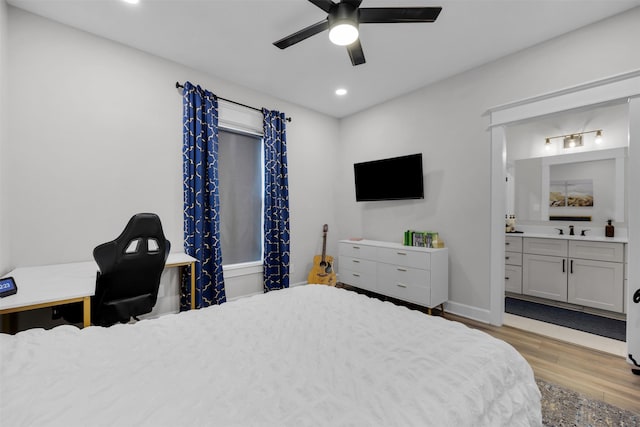 bedroom featuring connected bathroom, sink, ceiling fan, and light wood-type flooring