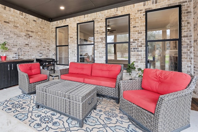 view of patio with an outdoor hangout area, sink, and grilling area