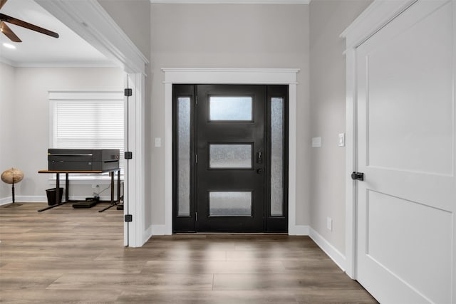 foyer featuring hardwood / wood-style floors, ceiling fan, and ornamental molding