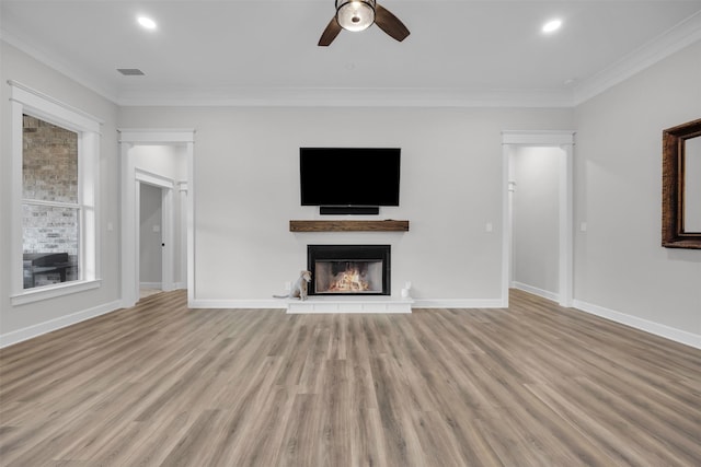 unfurnished living room featuring crown molding, plenty of natural light, ceiling fan, and light hardwood / wood-style floors