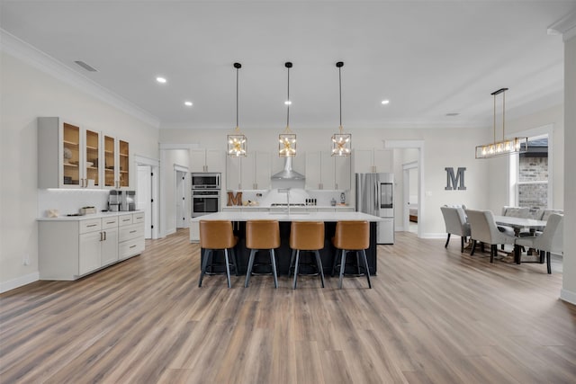 kitchen with white cabinetry, appliances with stainless steel finishes, a large island, and hanging light fixtures