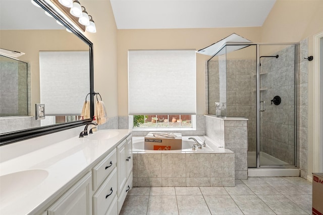 bathroom with vanity, tile patterned flooring, a relaxing tiled tub, and vaulted ceiling