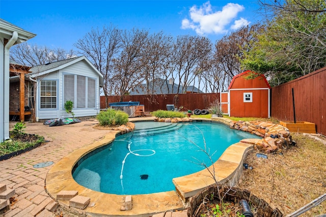 view of swimming pool featuring a storage shed, a jacuzzi, and a patio