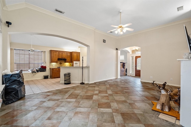 kitchen with a kitchen bar, decorative backsplash, stainless steel gas cooktop, a tile fireplace, and light tile patterned floors