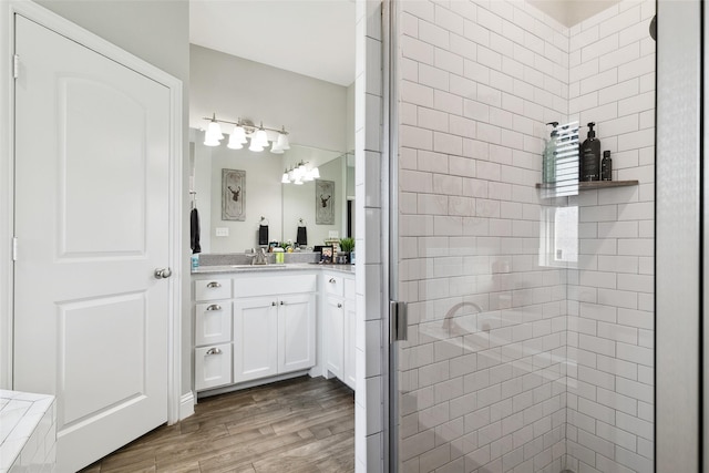 bathroom featuring vanity, wood-type flooring, and a shower with shower door