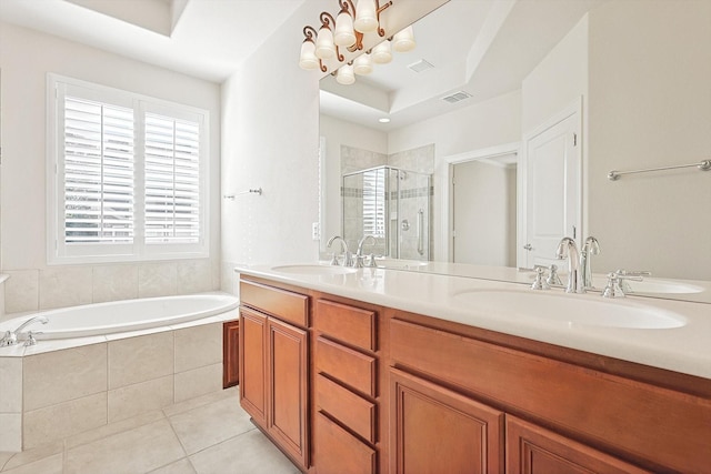 bathroom with tile patterned flooring, vanity, an inviting chandelier, and independent shower and bath