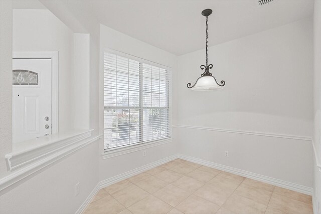 unfurnished dining area featuring light tile patterned floors and lofted ceiling