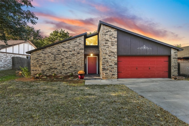 mid-century home with a garage, brick siding, concrete driveway, and a front lawn