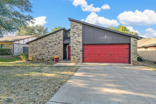 mid-century modern home featuring driveway, a front lawn, an attached garage, and brick siding