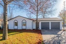 single story home featuring a front yard and a garage