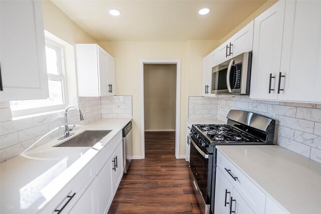 kitchen featuring stainless steel appliances, ceiling fan, dark wood-type flooring, sink, and white cabinetry