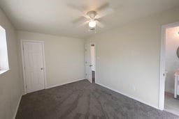 unfurnished bedroom with dark colored carpet and ceiling fan