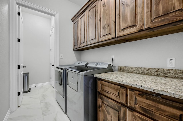 washroom with cabinets and washing machine and clothes dryer