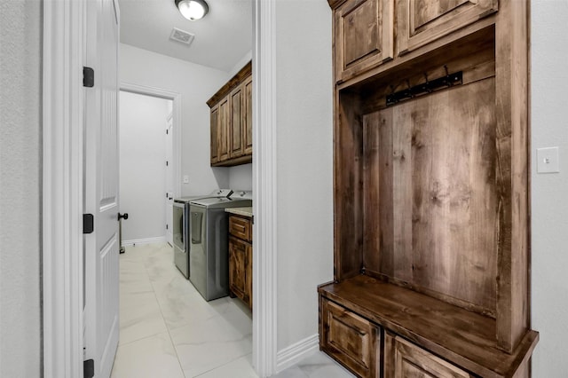 laundry room featuring washer and dryer and cabinets