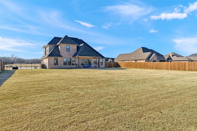 rear view of property featuring a yard