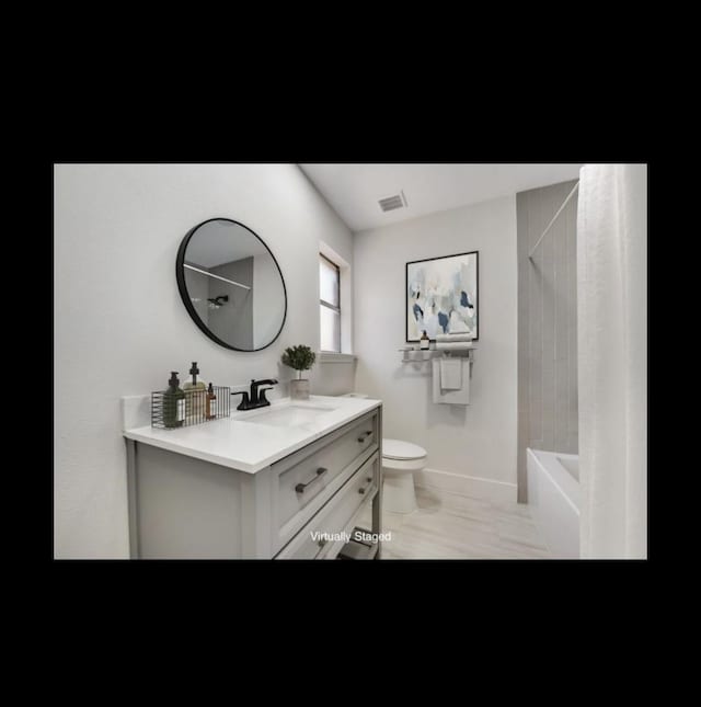 full bathroom with vanity, tiled shower / bath combo, and toilet