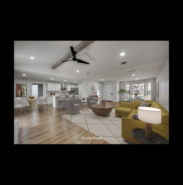 living room featuring vaulted ceiling with beams, light hardwood / wood-style flooring, and ceiling fan