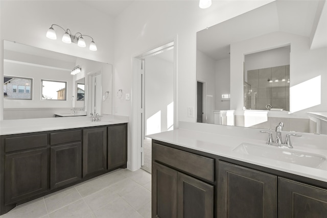 bathroom with vanity, tile patterned flooring, and a tile shower