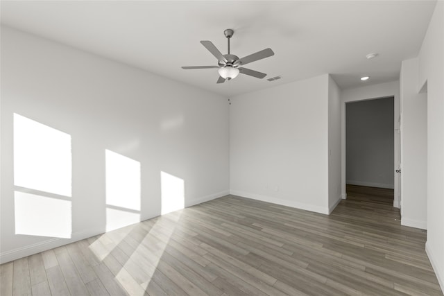 empty room with hardwood / wood-style floors and ceiling fan