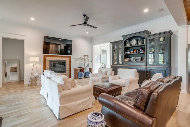 living room with ceiling fan, light hardwood / wood-style floors, and crown molding