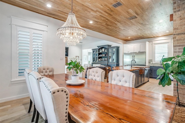 dining room featuring an inviting chandelier, light hardwood / wood-style flooring, and wooden ceiling