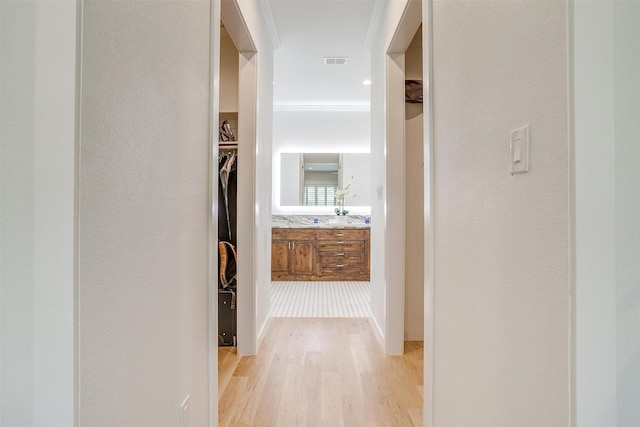 hallway featuring light hardwood / wood-style flooring and ornamental molding