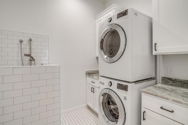 washroom featuring cabinets and stacked washer and clothes dryer