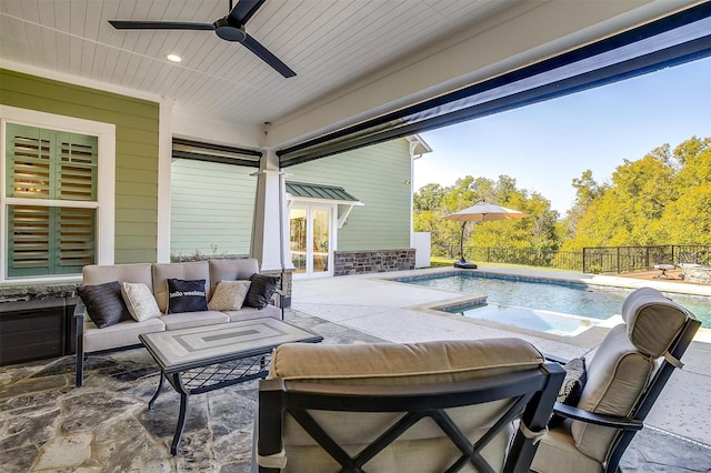 view of patio / terrace featuring ceiling fan, a swimming pool with hot tub, an outdoor living space, and french doors