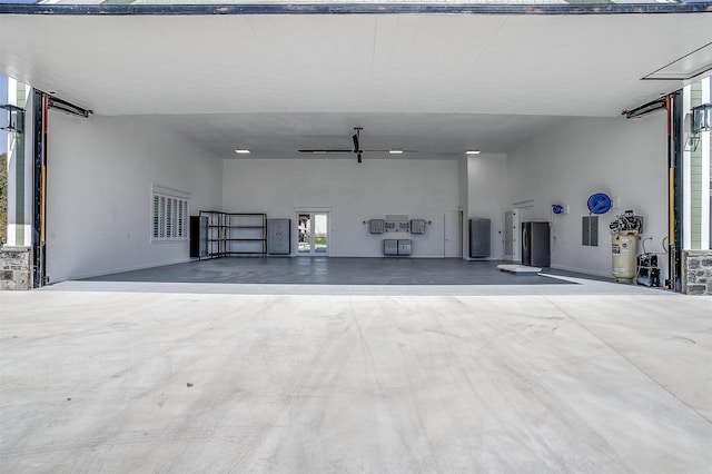 garage featuring fridge, electric panel, and ceiling fan