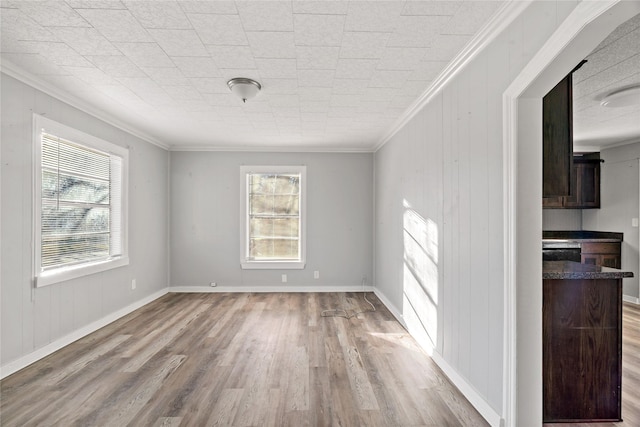 spare room featuring crown molding and light hardwood / wood-style flooring