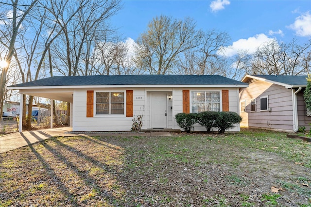 ranch-style home featuring a front lawn and a carport