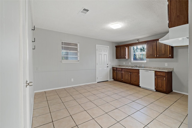 kitchen with white dishwasher, sink, and a textured ceiling