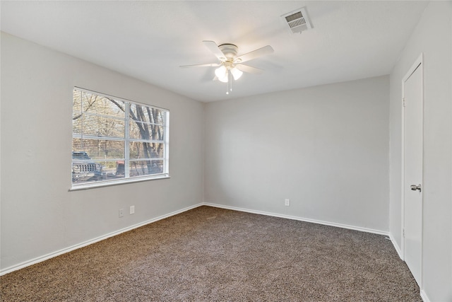 empty room with ceiling fan and dark colored carpet