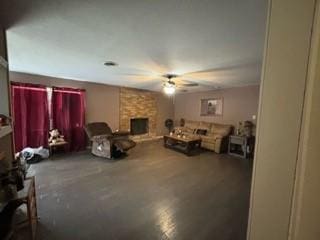 living room featuring ceiling fan and a fireplace