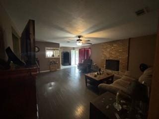 living room with ceiling fan and a brick fireplace