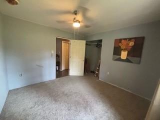 unfurnished bedroom featuring carpet flooring, ceiling fan, and a closet