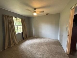 empty room featuring carpet flooring and ceiling fan