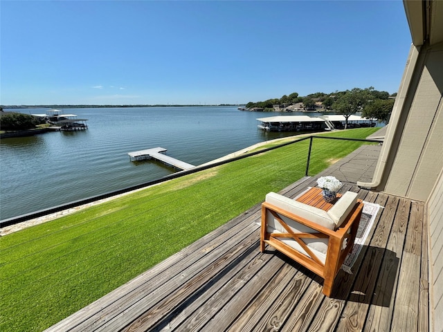 wooden deck with a lawn and a water view