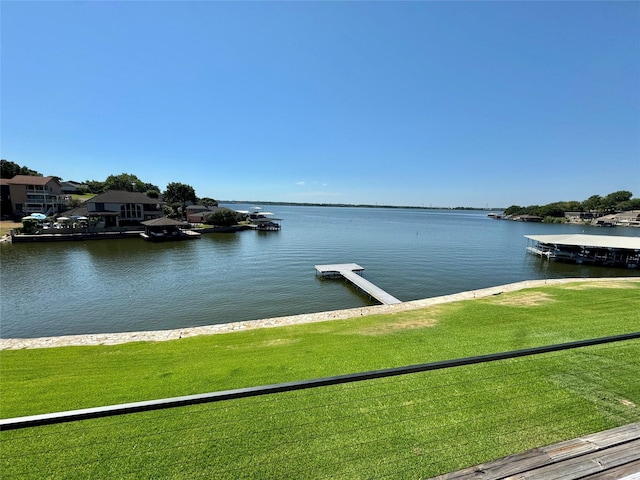 dock area featuring a lawn and a water view