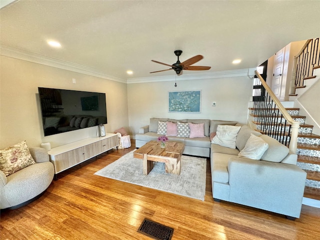 living room featuring ceiling fan, crown molding, and wood-type flooring